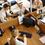 high angle view of a businessman and two businesswomen working in an office --- Image by © Royalty-Free/Corbis